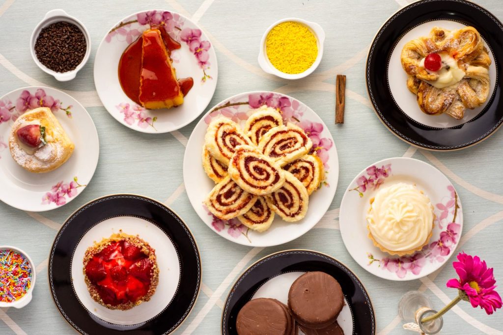 An assortment of mouthwatering pastries displayed on floral plates for a delightful treat.
